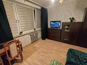 a living room with a television and a wooden floor at Mroczne marzenie in Przemyśl