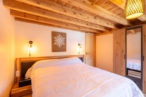 una camera da letto con un letto grande in una stanza con soffitti in legno di Cal Bénétou - Belle Maison pour 12, vue montagne a Les Angles