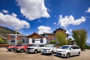 un grupo de coches estacionados en un estacionamiento en 阿乡哥田野归墅民宿馆, en Lijiang 81 fotos más