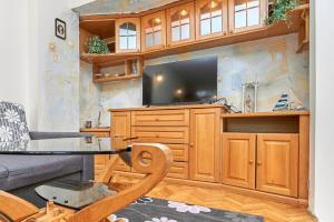 a living room with a tv and a couch and a table at Апартамент Бриз in Burgas