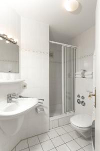 Un baño blanco con lavabo y ducha. en Residenz am Meer 24C Freissle, en Juist 33 fotos más