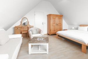 Un dormitorio con una cama, un sofá y una mesa. en Residenz am Meer 24C Freissle, en Juist