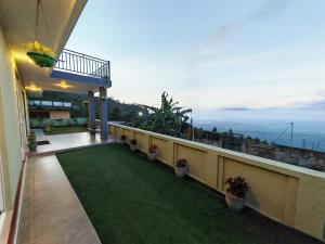 a balcony of a house with a green lawn at Trail Town Lodge in Haputale