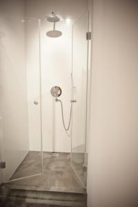 uma cabina de duche com uma porta de vidro e uma bobina de chuveiro em Loft Apartment Industrial Design em Cracóvia