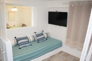 - un salon avec deux oreillers et une télévision dans l'établissement Endless Blue from Syros - Megas Gialos Suite 2, à Liaropá 38 autres photos