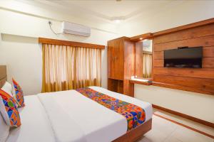 a bedroom with a bed and a flat screen tv at FabHotel Savi Inn - Nr Mantri Square Mall in Bengaluru