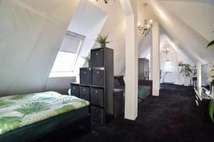 - une chambre avec un lit et une commode ornée de plantes dans l'établissement Zweistöckiger Traum über den Dächern STUTTGARTS, à Stuttgart