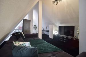 un salon avec un canapé et une télévision à écran plat dans l'établissement Zweistöckiger Traum über den Dächern STUTTGARTS, à Stuttgart