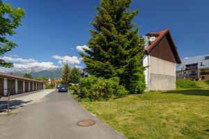 a car is parked next to a tree next to a building at Apartmán Tatry Lesná in Nová Lesná