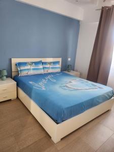 a bedroom with a large bed with blue walls at La nuvola in Fiumicino