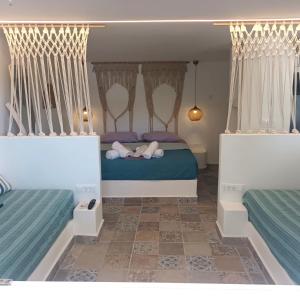 deux lits dans une chambre avec du bleu et du blanc dans l'établissement Endless Blue from Syros - Megas Gialos Suite 2, à Liaropá