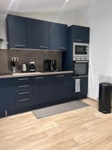 a kitchen with dark blue cabinets and appliances at Maison de ville neuve et moderne in Saint-Dizier