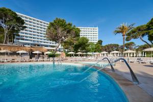 a pool with chairs and umbrellas and a hotel at AluaSoul Carolina - Adults Only in Font de Sa Cala