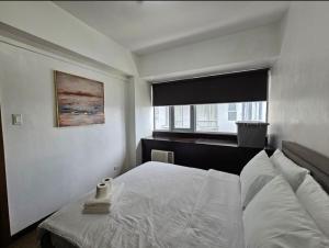 a bedroom with a bed and a window at Sunshine 100 Plaza - Bright and cozy 1 bedroom with washer in Manila +10 photos