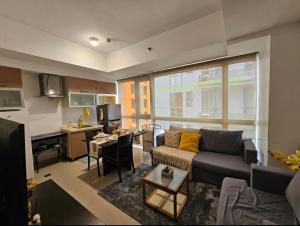 a living room with a couch and a kitchen at Sunshine 100 Plaza - Bright and cozy 1 bedroom with washer in Manila