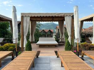 迪利然Dilijani Tun Hotel & Restaurant的天井上配有床和长凳的凉亭