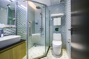 un bagno con doccia, wc e lavandino di 趣创酒店 a Shenzhen