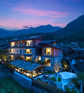 Villa con vistas a las montañas por la noche en 阿乡哥田野归墅民宿馆, en Lijiang