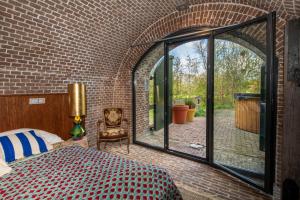 a bedroom with a bed and a large glass window at Fort Vuren in Vuren