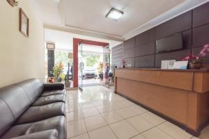 a lobby with a couch and a reception desk at Urbanview Hotel Sakura Bandung in Bandung