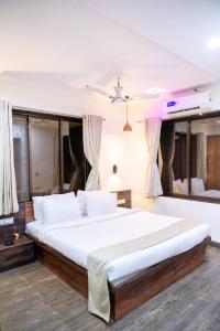 a bedroom with a large bed with white sheets at Siddhant Hill Resort in Revadanda +81 photos