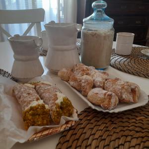 a table with pastries and a bottle of milk at La Cortese, cuore barocco in Noto +39 photos