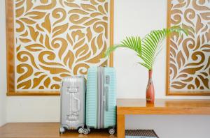 two suitcases sitting on a table next to a vase at Khách Sạn Bình Minh in Phan Thiet