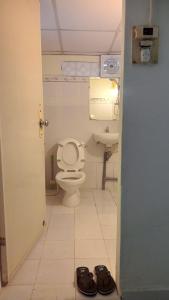 a bathroom with a toilet and a sink and a pair of shoes at Dorm Can Tho in Can Tho +14 photos