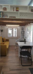 a living room with a table and a yellow couch at Camping Costa Dorada Tiny Berna in Canet de Mar