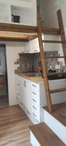 a kitchen with white cabinets and a wooden staircase at Camping Costa Dorada Tiny Berna in Canet de Mar +8 photos