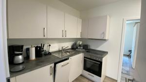 a kitchen with white cabinets and a sink at Haus am Hafen Friedrichskoog App1 Hindenburg in Friedrichskoog