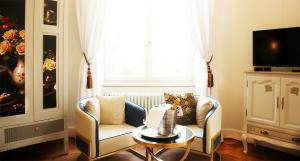 a living room with a chair and a table and a window at Chateau Morreau in Péruwelz