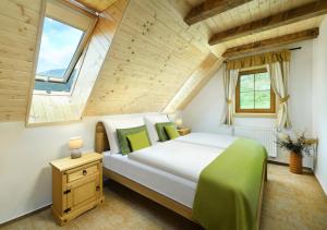 a bedroom with a large white bed and a wooden ceiling at Apartmány a Štúdiá Lúčky, SKI-IN SKI-OUT ,Chopok Jasná, Demänovská dolina in Demanovska Dolina