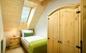 a small bedroom with a bed and a wooden cabinet at Apartmány a Štúdiá Lúčky, SKI-IN SKI-OUT ,Chopok Jasná, Demänovská dolina in Demanovska Dolina +26 photos