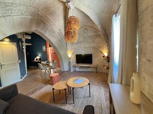 a living room with a couch and a table at Joli appartement voûté dans le centre ville in Avignon