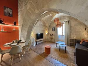 a living room with a couch and a tv at Joli appartement voûté dans le centre ville in Avignon +2 photos