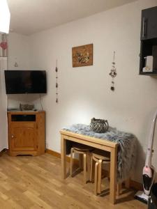 a room with a table with a cat sitting on it at L'étoile des neiges Studio confort pour 4 personnes in Montclar +17 photos