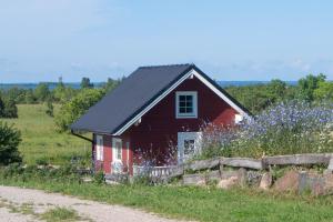 a red barn in a field with purple flowers at Anne's Cottage in Saastna