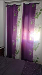 a bedroom with purple curtains with plants on the wall at Habitación con Vistas Preciosas en Piso Compartido in Estepona