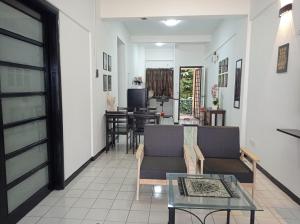 a living room with a couch and a table at Adira Corus Paradise Seaview Family Suite in Port Dickson