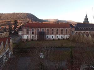 an old building with a hill in the background at Appartement cosy calme & central in Senones
