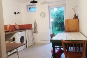 a kitchen with a table and a washing machine at Appartement cosy calme & central in Senones