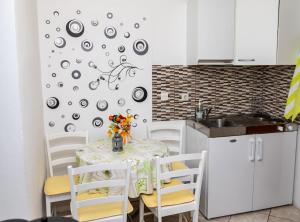 - une cuisine avec une table, des chaises et un évier dans l'établissement Apartments Luka & Leona, à Senj