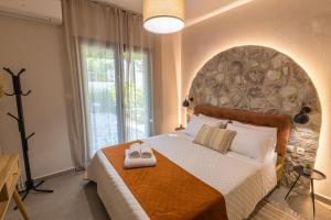 a bedroom with a large bed with a stone wall at Relax house by the sea in Volos