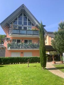 a large house with a balcony and a yard at Appartement Sulzbachtal in Lahr, Nähe Europapark, Nähe Rulantica in Lahr