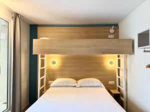 Rúm í herbergi á Kyriad DIRECT Saint Brieuc - Parc des Expositions