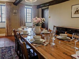 a dining room with a wooden table with chairs and flowers at Elizabethan Manor at gateway to the Brecon Beacons in Abergavenny