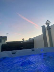 una vasca idromassaggio con acqua blu di fronte a un edificio di Premium accommodation with luxury HOT-TUB and decking area, near Fantasy Island a Ingoldmells