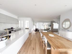 a kitchen and dining room with a wooden table at Riva House in Summerland Point