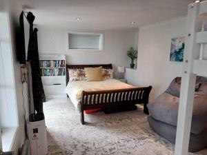 a bedroom with a bed and a book shelf at The Harbour Masters Cottage in Tairua